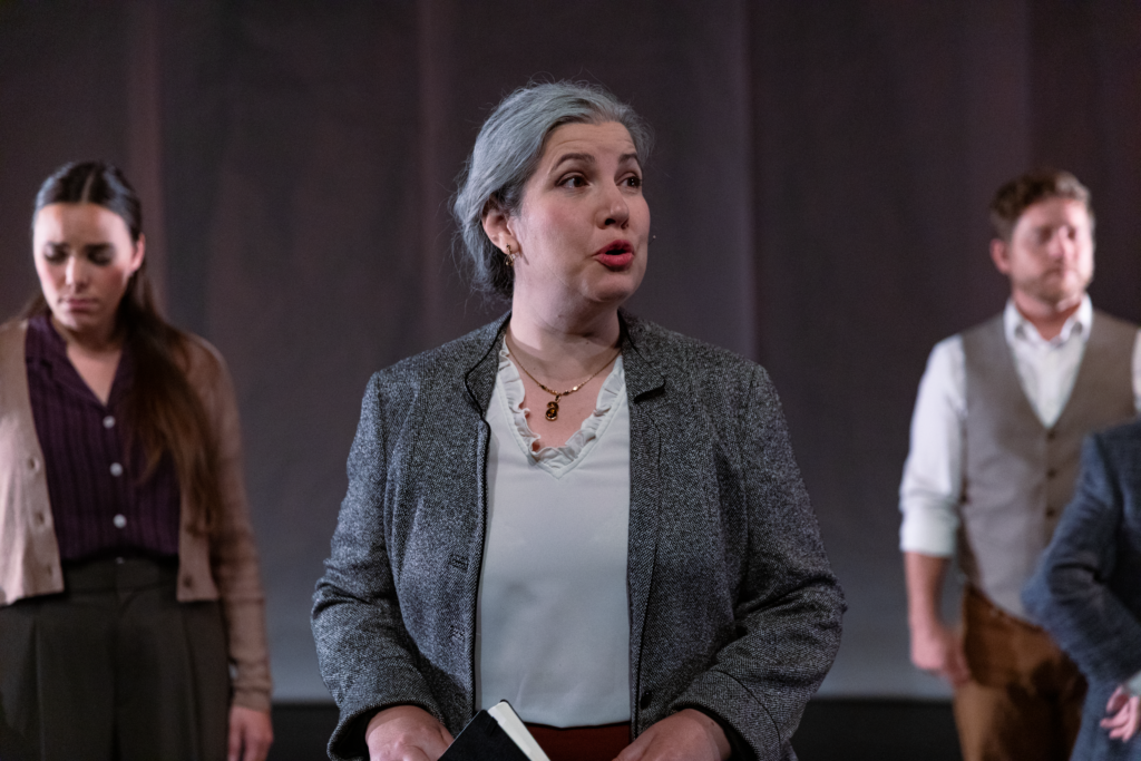 Maren Montalbano looking to the right, with two people out of focus in the background.