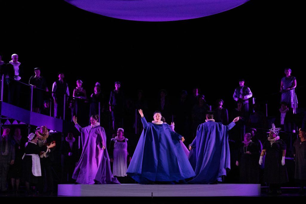 performers in blue and purple robes dancing on stage