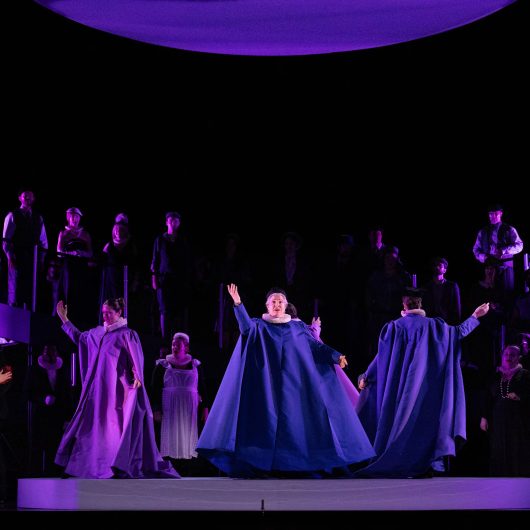 performers in blue and purple robes dancing on stage